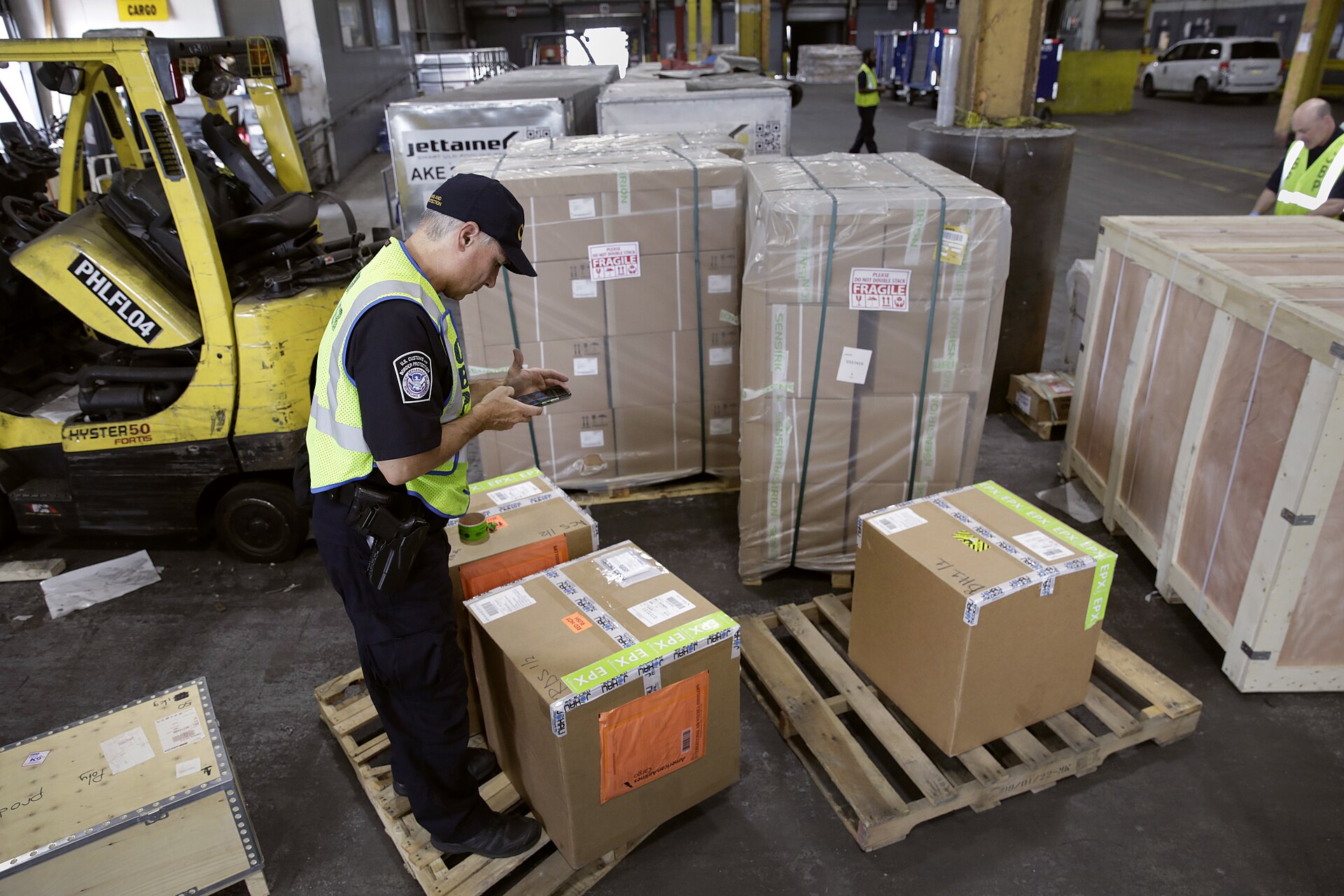 An officer checking packages in a cargo warehouse